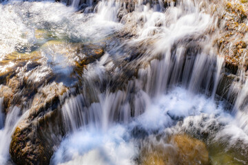 long exposure in a small waterfall in a mountain river of fresh and pure waters,  mountain snowmelt torrent