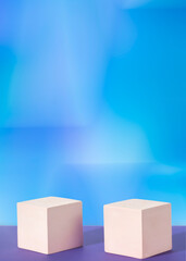 Two cement cube podiums on a gradient blue background. Mockup for the demonstration of cosmetic products. Vertical photo
