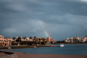 Regenbogen über El Gouna, Ägypten mit Häusern im nubischen Baustil an der Lagune mit Booten