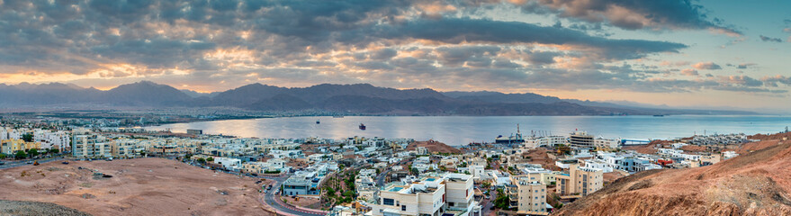 Fototapeta na wymiar Panorama. Morning aerial view on the Red Sea. Scenic landscape with surrounding mountains and buildings of Eilat (Israel) and Aqaba (Jordan) cities. 