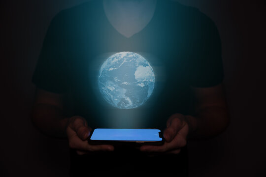 A man in the future holds a on which the planet earth is projected. New technology.