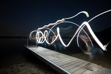 light swirls on a small pier at night - Powered by Adobe