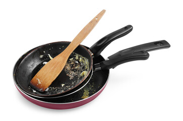 Dirty frying pans and wooden spatula on white background