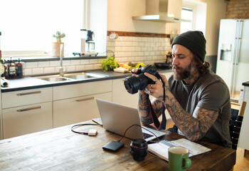 Young adult photographer at home going over the footage he shot