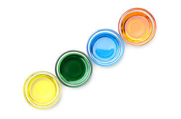 Glass bowls with different food coloring on white background, top view