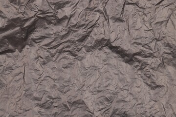 Crumpled black plastic bag as background, top view