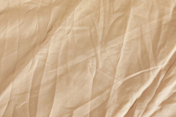 Fototapeta na wymiar Crumpled beige fabric as background, top view