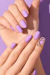 Womans hands with fashionable purple manicure. Spring summer nail design