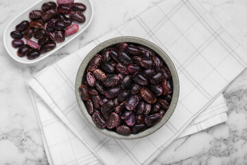 Bowls with dry kidney beans on white marble table, flat lay