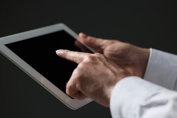 Closeup view of man using new tablet on black background