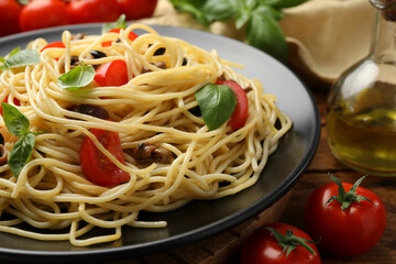 Delicious pasta with anchovies, tomatoes and olives on table, closeup