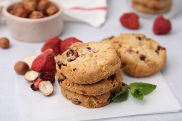Cookies with freeze dried fruits, nuts and mint on white table, closeup