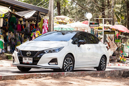 White Nissan Almera on the road near the cafe