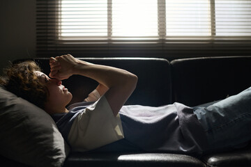 Side view of young stressed woman describing her worries to counselor or psychotherapist during...