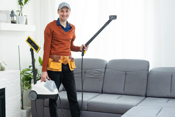 Dry cleaner's man employee removing dirt from furniture in flat, closeup, vacuum clean sofa with professional equipment.