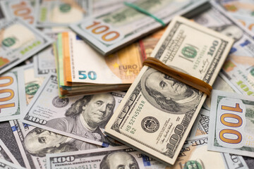 200 Euro banknote next to 50 euros on top of one hundred dollar bills. Trading Euro with Dollar