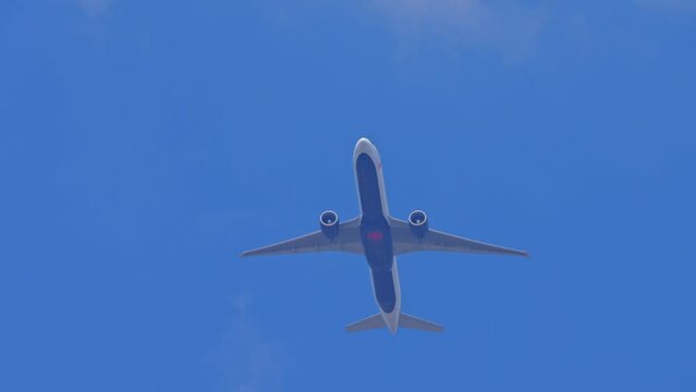 Airplane Air Canada passing overhead near the airport. Air passenger plane bottom view while flying. Jet aircraft departure climb in the blue sky 