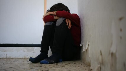 domestic violence. little boy with bruises and abrasions autistic on her face punished in the corner crying tears. domestic child abuse fear concept. child is punished and beaten afraid of fear