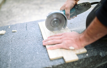 Closeup of a worker use cutting machine to cut a ceramic tile