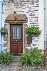 Old rustic wooden door, in the town of Salers in Auvergne, France