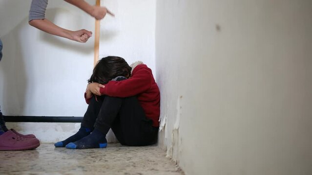 domestic violence. little boy with bruises and abrasions autistic on her face punished in the corner crying tears. domestic child abuse fear concept. child is punished and beaten afraid of fear