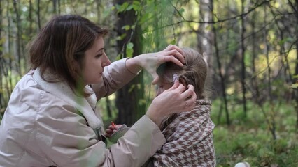 Hello September. A young mother and little daughter walk in the city park in autumn.