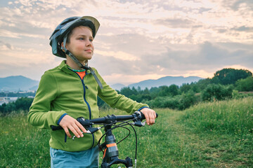Child to ride bicycle outdoors, Happy cute boy in helmet go  sports in summer day