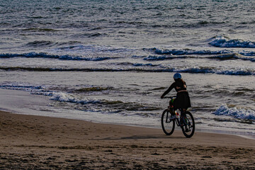 Fototapeta premium Girl riding a bicycle on the beach