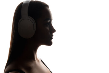 Music chill. Sound technology. Closeup backlit profile silhouette of calm woman listening to audio in wireless headphones on white empty space background.