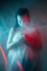 Obraz na płótnie Canvas Air pollution. Toxic smog. Environment contamination. Climate disaster. Red blue color light defocused exhausted suffering woman silhouette in smoke cloud.