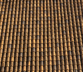 Old tile roof above the house and hard shadows from sunny in a summer day. Aerial top view from drone. Beautiful background.