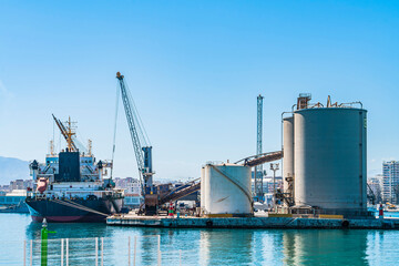 Industrial Port of Malaga, Spain. Bulk carrier in dry bulk terminal, near cement bunkers
