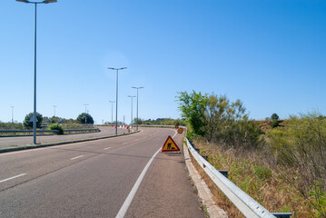 Carretera con curva en obras con señales de advertencia.