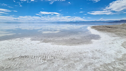 Panoramic view of the white salt beach at lake of Bonneville Salt Flats, Wendover, Western Utah, USA, America. Beautiful mountain reflections. Looking at summits of Silver Island Mountain range