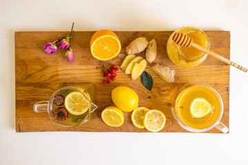 Making healthy ginger tea with lemon and honey on wooden table close-up