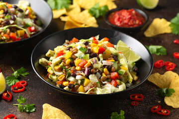 Mexican style salad of black beans, lentils, corn, tomato and lettuce with a salsa and tortilla chips