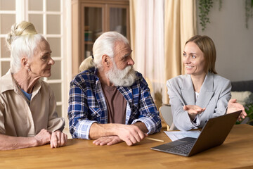 Financial consultant using laptop and explaining the financial literacy to senior couple during their meeting at home