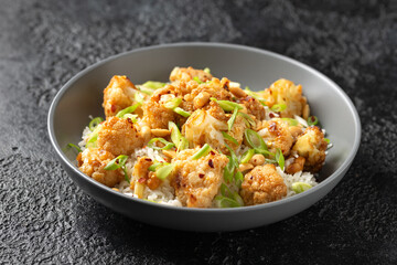 Kung Pao Cauliflower with rice, peanuts and spices. Healthy vegan food.