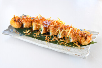 Variety of sushi rolls are presented on a plate, showcasing the colorful and fresh ingredients.