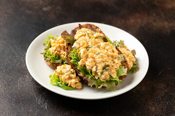 Egg salad sandwiches with greens and herbs on white plate. Healthy food.