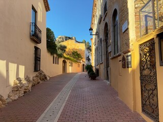 Obraz premium View through an alley in the old town of Begur in the evening light, Catalonia, Spain