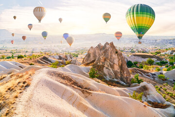 Obraz premium Landscape of scenic valley with colorful flying hot air balloons in Anatolia, Kapadokya. Beautiful destination in Nevsehir, Goreme
