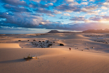 Sand dunes in Las Dunas de Corralejo, Corralejo Natural Park, dramatic cloud formation, Fuerteventura, Canary Islands, Spain. Sand dunes landscape, Corralejo, Fuerteventura, Canary Islands, Spain.