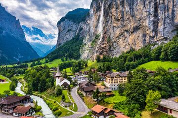 Amazing summer landscape of touristic alpine village Lauterbrunnen with famous church and Staubbach...