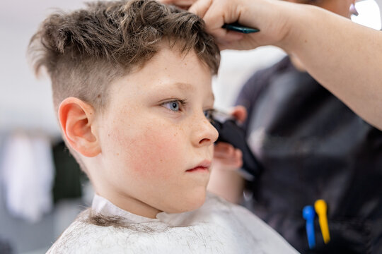 Anonymous stylist cutting hair of child client