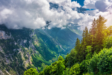 Panoramic view of idyllic mountain scenery in the Alps with fresh green meadows in bloom on a beautiful sunny day in summer, Switzerland. Idyllic mountain landscape in the Alps with meadows in summer.