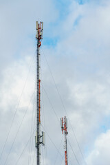 Obraz premium New GSM antennas on a tower against a blue sky for transmitting a 5g signal are dangerous. Radiation pollution of the environment through cell towers. New technologies in the field of communication.