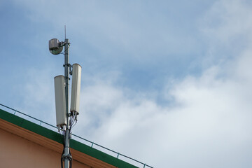 Obraz premium New GSM antennas on the roof of a residential building in the city for transmitting a 5g signal are a danger to human health. Radiation pollution of the environment through cell towers.