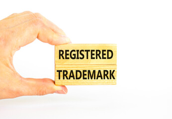 Registered trademark symbol. Concept word Registered trademark on wooden blocks. Beautiful white table white background. Businessman hand. Business and registered trademark concept. Copy space.