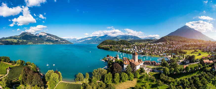Aerial panoramic view of Spiez Church and Castle on the shore of Lake Thun in the Swiss canton of Bern at sunset, Spiez, Switzerland. Spiez Castle on lake Thun in the canton of Bern, Switzerland.